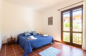 a bedroom with a blue bed and a large window at Casa del Lentischio in Oristano