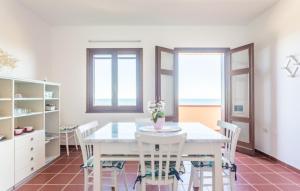a white dining room with a white table and chairs at Casa del Lentischio in Oristano