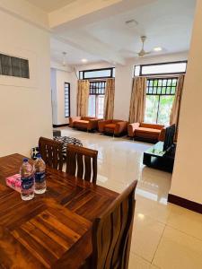 a living room with a wooden table and chairs at Azys Inn 3 Bedrooom Apartment - 1st Floor in Kalubowila West
