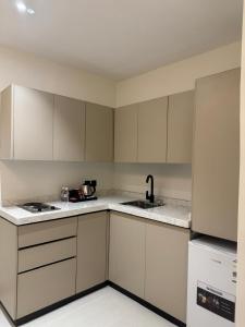 an empty kitchen with white cabinets and a sink at فندق اللحظات السعيدة in Riyadh