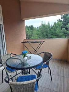 a patio table and chairs on a balcony with a view of trees at Apartment Mate in Bibinje
