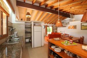 a kitchen and living room with wooden ceilings at Ca Na Barbara in Santanyi