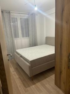 una piccola camera da letto con un letto e una finestra di S&M Suncani Breg a Kopaonik
