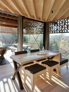 a wooden table and chairs in a room with a large window at Hutstuf - The Rac00n & hottub in Bertogne +9 photos