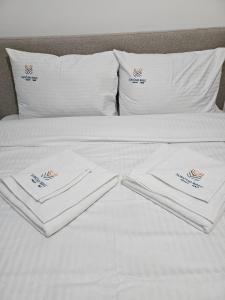 un letto bianco con due asciugamani bianchi di S&M Suncani Breg a Kopaonik Altre 23 foto