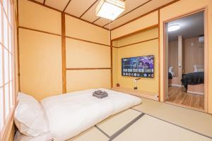 a small room with a bed and a tv at skytree Family Hotel in Tokyo