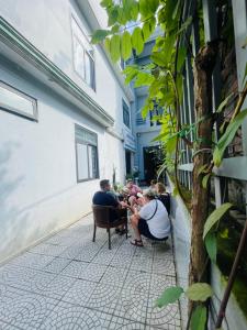 a group of people sitting on chairs on a sidewalk at SAPHIA Hotel Hue in Hue