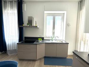 a kitchen with a sink and two windows at Milano Duomo Design Apartment in Milan +28 photos