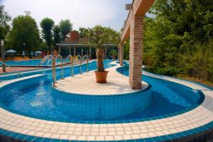 a swimming pool with a palm tree in the middle at Holiday Beach Budapest Wellness Hotel with Sauna Park in Budapest