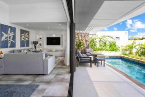 Villa Tapya - Amazing Villa with private pool في كاب مالهيريوكْسْ: غرفة معيشة مع أريكة ومسبح