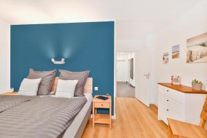 a bedroom with a blue wall and a bed at Inselblick Klausdorf - Entspannung an der Küste in Klausdorf Mecklenburg Vorpommern