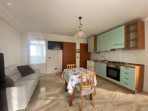 a kitchen and living room with a table and a couch at Casa Athena in Cerignola