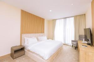 a hotel room with a bed and a television at Paradise Court by LLA in Accra +29 photos