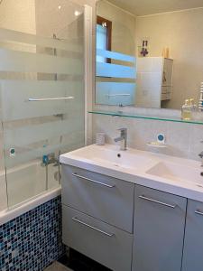 un bagno con un lavandino, uno specchio e una vasca di Chambres tout confort du Tilleul a Bosc-Bénard-Commin Altre 36 foto