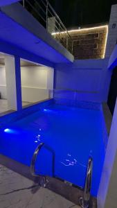 a large pool with blue lighting in a building at The grange valley view in Panchgani