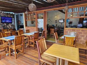 a restaurant with wooden tables and wooden chairs at Pousada Mãe Natureza in Pirenópolis