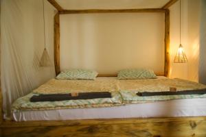 a bed with two pillows on it in a room at Hakuna in Arusha +9 photos