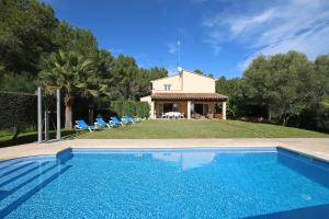 a villa with a swimming pool in front of a house at Son Cami in S'Horta