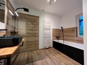 a bathroom with a black tub and a sink at Meine HarzZeit in Goslar