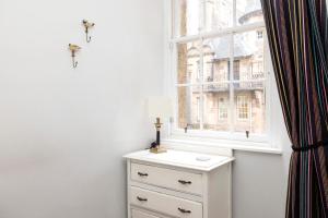 Vestidor blanco con lámpara y ventana en JOIVY Classy Apartment near Edinburgh Castle, en Edimburgo 13 fotos más