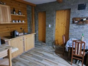 a kitchen with wooden cabinets and a table and chairs at 7 kruna Žiče in Žiča