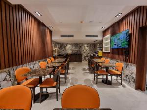 a restaurant with tables and chairs and a large screen at RIJJI HOTEL ISTANBUL OLD CiTY in Istanbul