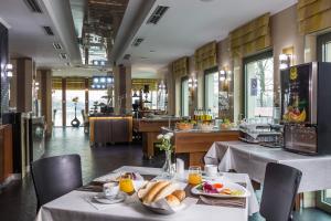 a restaurant with two tables with plates of food at Holiday Beach Budapest Wellness Hotel with Sauna Park in Budapest