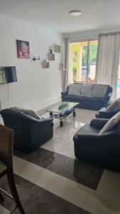 a living room with blue couches and a table at Elegant 3 bedrooms of 3 Apartments in Rivière Noire