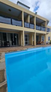 a house with a swimming pool in front of it at Elegant 3 bedrooms of 3 Apartments in Rivière Noire