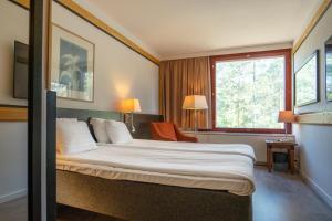 a hotel room with a bed and a window at Hotel Korpilampi in Espoo