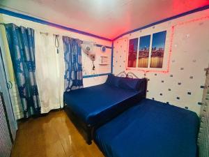 RodriguezにあるMG 6pax 1 AC BR 200mbps FREE Netflix Parking Cignal Videoke Shower Heater Cook & Grillのネオンライト付きの部屋にベッド2台が備わる部屋