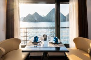 a dining room table with a view of the water at Dragon Premium Cruise Halong in Ha Long