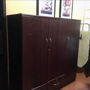a wooden cabinet with two doors in a room at MG 5pax 1 AC BR 300mbps FREE Netflix Parking Cignal Videoke Shower Heater Cook & Grill in Rodriguez