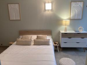 a bedroom with a white bed and a dresser at Aparthotel Des 2 Caps in Ambleteuse