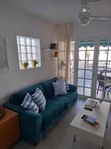 Una sala de estar con un sofá azul y una mesa. en Casa Salome by El Sirocco, en Puerto de Mogán