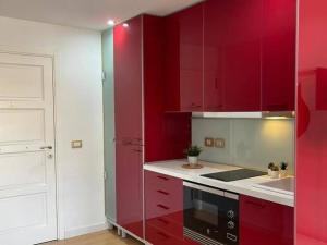 a kitchen with red cabinets and a black microwave at Aldaba by Huskalia in Los Llanos de Aridane