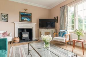 a living room with a fireplace and a tv at East House in High Legh