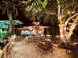 a restaurant with tables and chairs and a tree at night at Cirandeira Amazon World EcoResort in Manacapuru