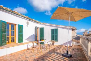 a patio with a table and an umbrella at Ca N'Abrines in Lloseta