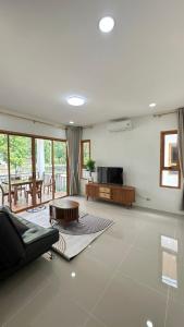 a living room with a couch and a table at Jenny Garden House in Ban Madua Wan