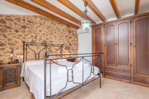 a bedroom with a bed and a stone wall at Ca N'Abrines in Lloseta