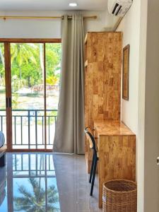a room with a desk and a large window at Jenny Garden House in Ban Madua Wan