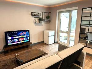 a living room with a couch and a flat screen tv at Leamington Spa-3 Bed-Garden-Pets-Free Parking in Leamington Spa