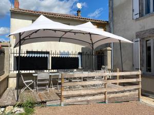 - un parasol blanc sur une table et des chaises dans l'établissement Chambre Songes d'Afrique, à Montournais