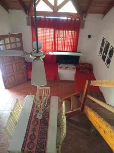 Ofrece vistas a una sala de estar con sofá rojo. en Tinkunaco Merlo, en Merlo