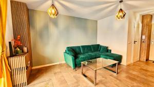 a living room with a green couch and a table at Vision Luxury Marina in Wrocław