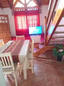 Un comedor con una mesa y un televisor. en Tinkunaco Merlo, en Merlo