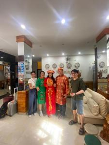 a group of people posing for a picture in a living room at SAPHIA Hotel Hue in Hue