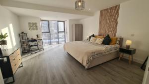 a bedroom with a bed and a large window at Modern City Apartment in Hemel Hempstead