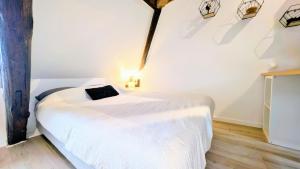 Un dormitorio con una cama blanca en una habitación. en Cocon Centre ville Auxerre Cosy, en Auxerre